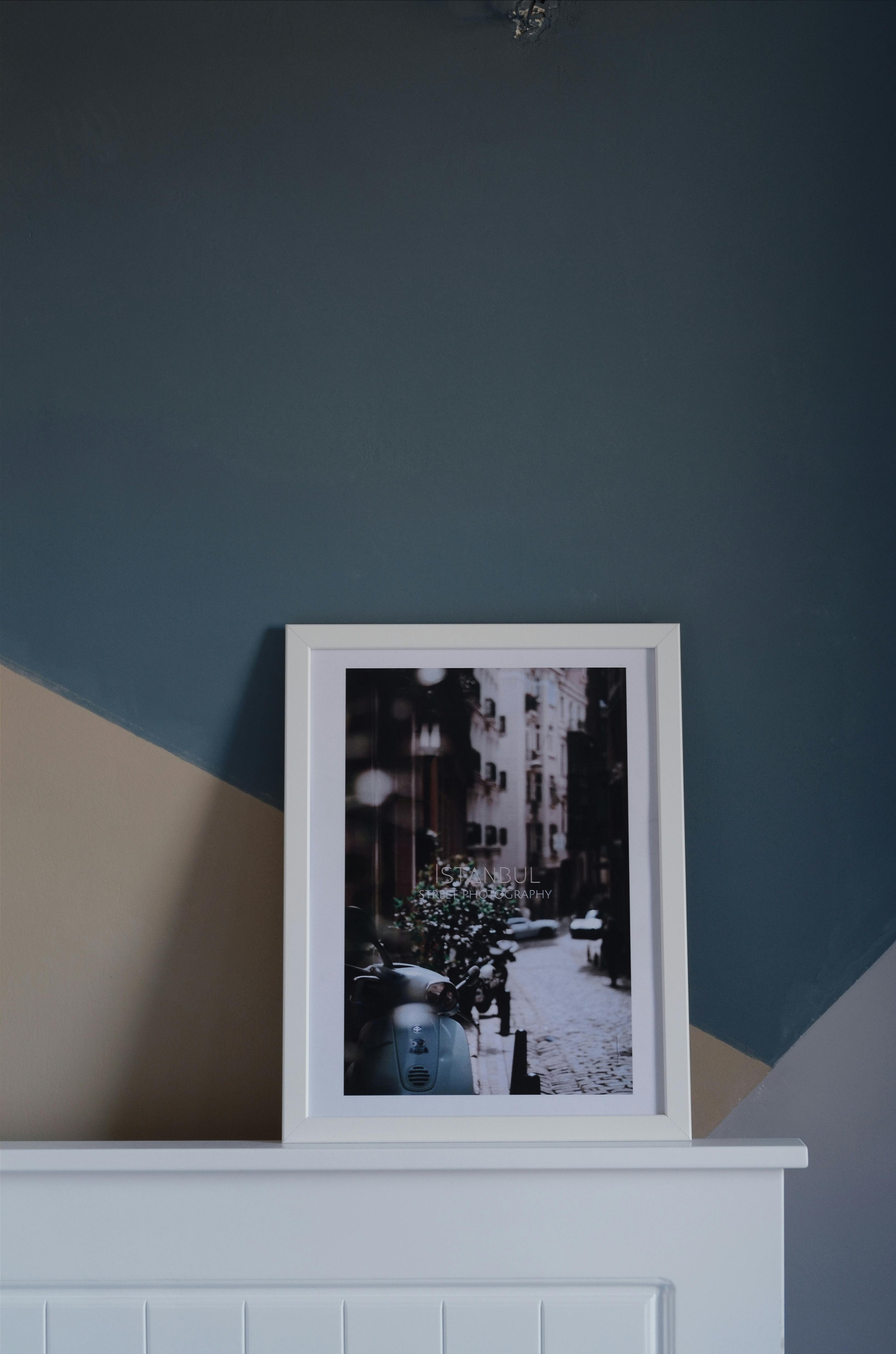 Minimalist interior featuring a framed urban photo against geometric painted wall.